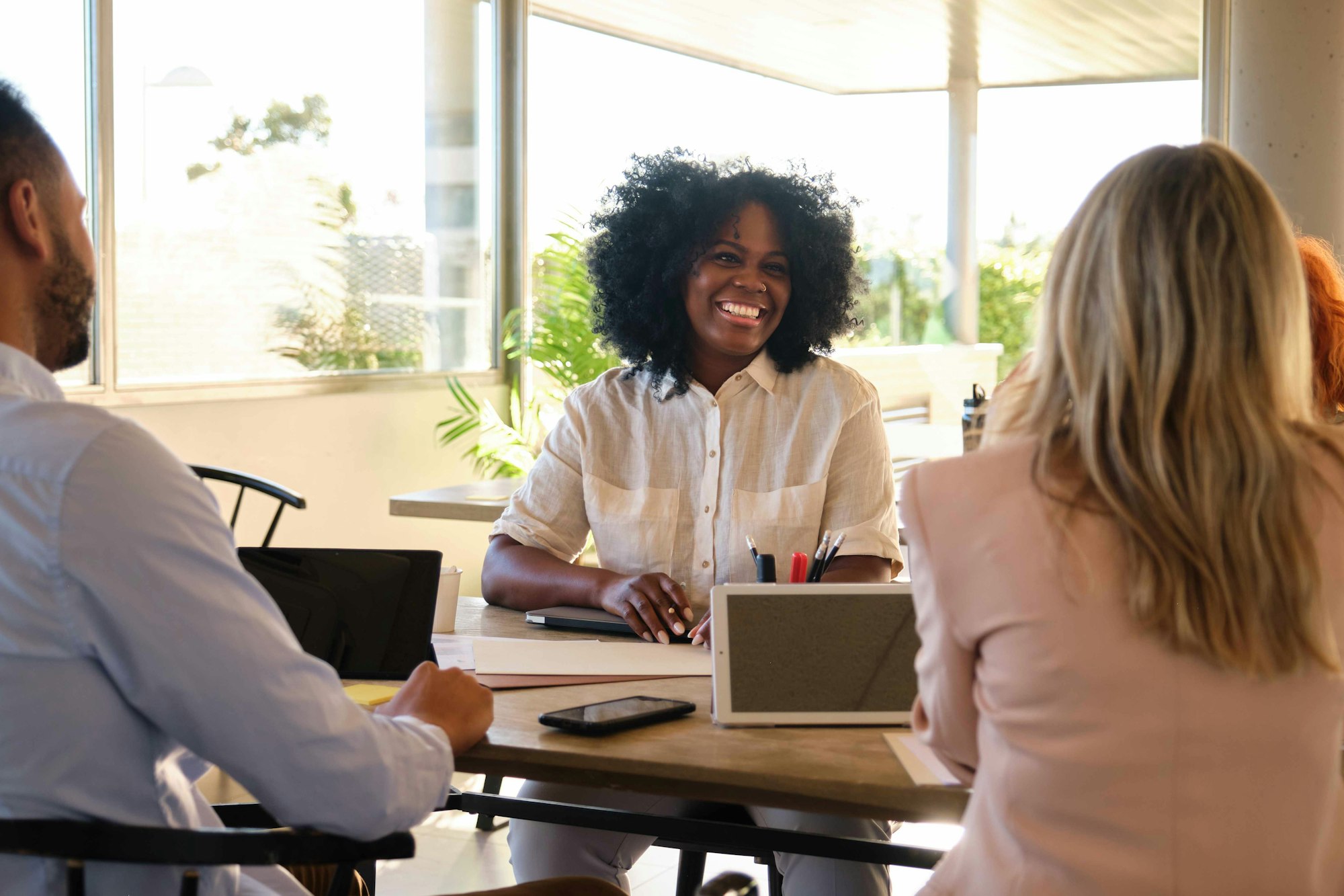 Black businesswoman smiling in a company startup meeting.